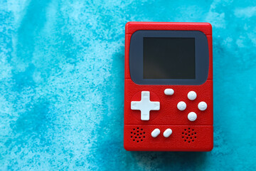 Retro video game console on a blue background, top view.