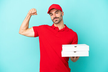 Delivery caucasian man picking up pizza boxes isolated on blue background doing strong gesture