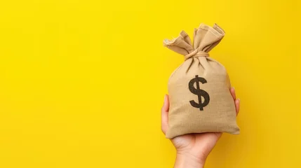 Fotobehang Female hand holding a sacks of money for trading ideas. Or financial investment on yellow background, generative ai © OP38Studio