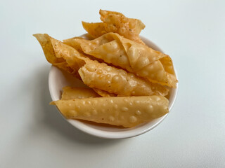 Kerupuk pangsit, or crispy fried dumpling, inside a white bowl, isolated in white background