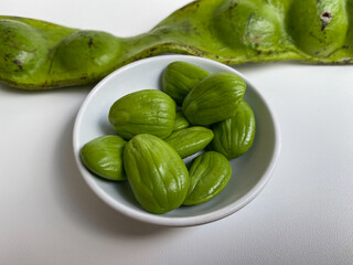 Parkia speciosa, the bitter bean, petai, or pete. Before and after peeled. Isolated on white background