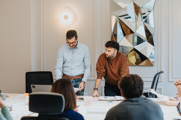 Two men are actively discussing business matters in a well-lit office with attentive colleagues. The serious ambiance conveys a sense of collaboration.