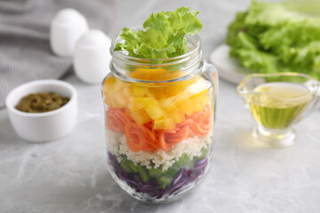 Obraz na płótnie Canvas Healthy salad in glass jar on marble table