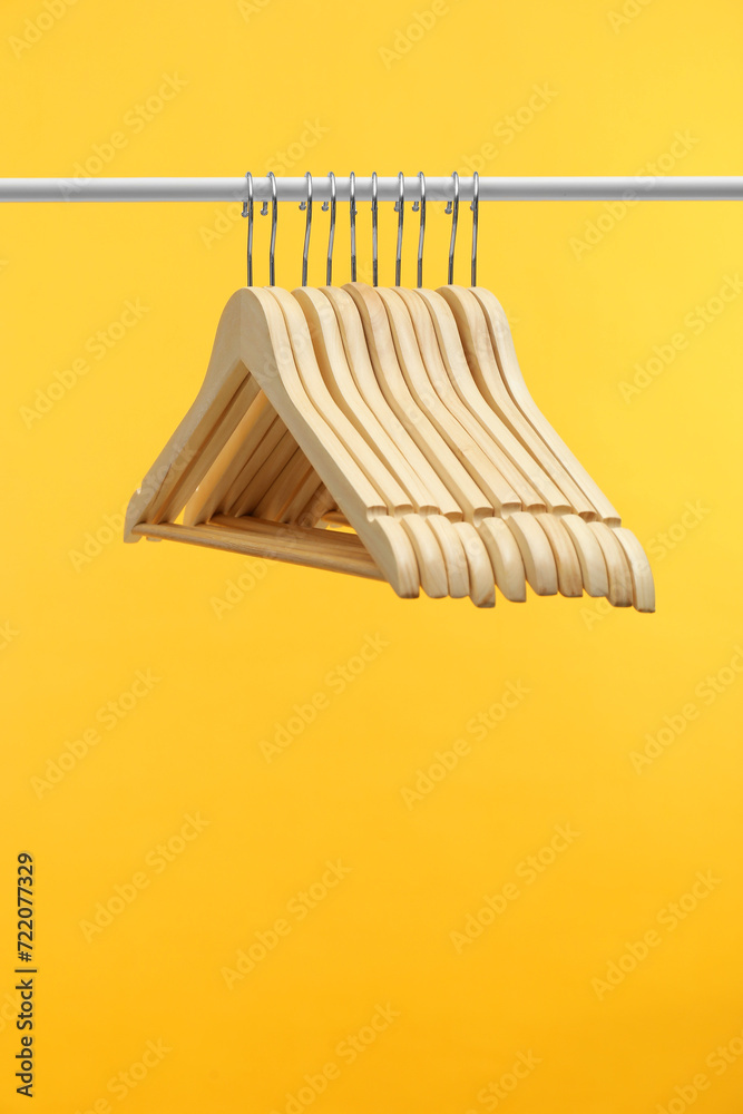 Canvas Prints Empty clothes hangers on rack against orange background