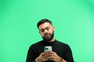 Man, close-up, on a green background, using a phone