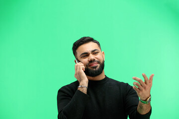Man, close-up, on a green background, talking on the phone