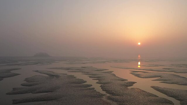 Beach scenery with mudflats overlooking the sunrise
