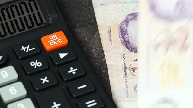 Singapore money, Taxes and financial settlements, Business and economic concept, Calculator and deductible banknotes, Singapore dollars, Low denominations, home budget