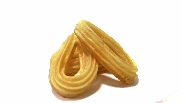 Spinning churros , isolated on a white background. A churro consists of a dough made of flour, water and salt. Once the dough is made, they are fried in oil, sometimes coated in sugar.