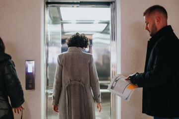 Two business professionals entering a secure building by using an access control system, depicting workplace security and smart building access.