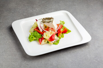 Greek salad in a plate gray background