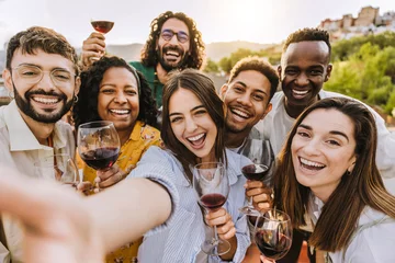 Fototapeten Multiracial friends drinking red wine outside at farm house vineyard countryside - Group of young people taking selfie picture outdoor - Life style concept with guys and girls enjoying summer vacation © Davide Angelini