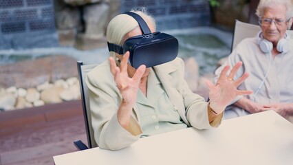 Senior woman gesturing while using virtual reality goggle in geriatric