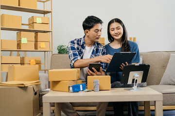 couple start up small business owner writing address on cardboard box at workplace.small business entrepreneur SME or freelance asian couple working with box at home.