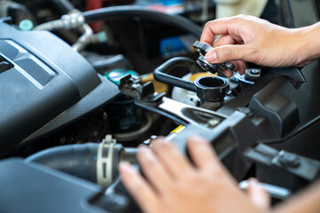 A woman is opening the car's radiator cap