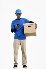Fototapeta na wymiar The deliveryman, in full height, on a white background, with a box and a phone
