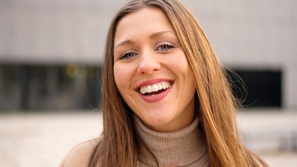 Young female student smiling at camera outdoors