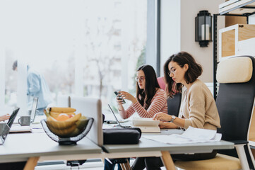 Female coworkers collaborating in a modern office. Enthusiastic teamwork, innovation, and profitability. Entrepreneurs, different ages and races, creative employees.