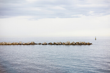 Advanced seawall in the sea, breakwater drawing the horizon at sunset on the coast.