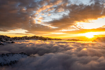 Fototapeta na wymiar Mount Siguniang, Four Girls Mountain the Sacred Mountain in the East, National Geo-park of China, Sunset over a sea of clouds in the mountains with golden light touching snowy peaks
