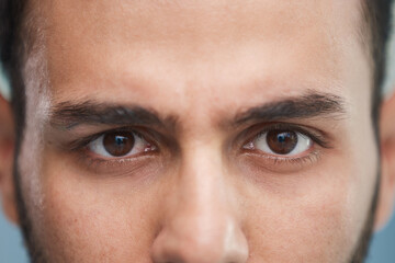 young beautiful man with brown eyes looks at the camera.