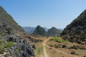 A scenic trail winding through mountainous terrain under a clear blue sky.