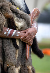 Human hand holds ritual clapsticks for the welcome ritual rite at an indigenous community event in...