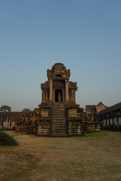 A person standing in the doorway of an ancient temple at dusk