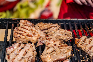 The meat is fried on a hot grill. Grilled steaks.
