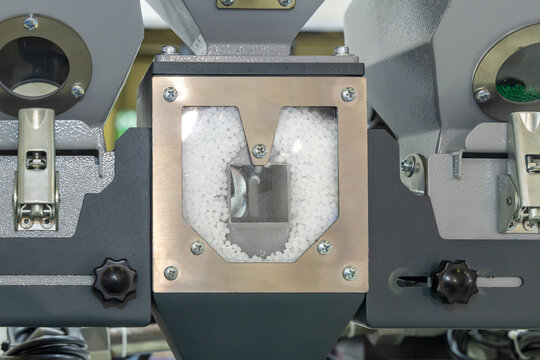 Fragment of a production line for molding plastic products. Close-up of the hopper and mixer of an injection molding machine with polypropylene granules ready for heat treatment