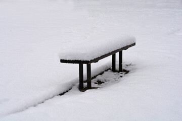 Bench covered in snow in winter