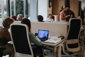 Focused professionals in a vibrant office setting, showcasing teamwork and productivity. Collaborative workspace with technology in use.