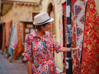 female summer travel to Antalya, Turkey. young asian woman in red dress walk old town Kalechi ,...