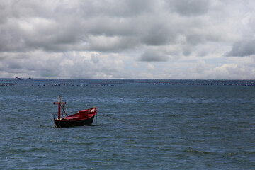 Fototapeta premium A fishing boat floats in the middle of the sea..
