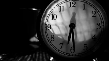 An alarm clock indicates seven o'clock.