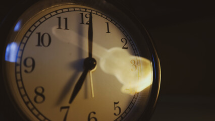 An alarm clock indicates seven o'clock.