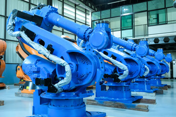 Blue robot arms assemble for automotive industry.Automated production line with robotic arms in factory.