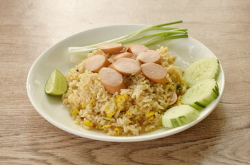 fried rice pork sausage and egg with slice cucumber couple lemon on plate 