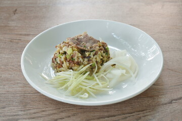 fried rice with pork topping slice onion and mango on plate 