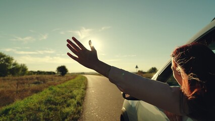 girl rides car with her hand out window, sun glare sunset, wind face, summer vacation mood, people...