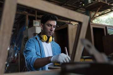 Male carpenter working at woodwork workshop. Male joiner working in furniture workshop