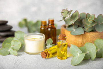 Eucalyptus essential oil in a glass bottle with green eucalyptus leaves on a textured wooden background. Aromatherapy concept. Spa. Natural organic ingredients for cosmetics and body care.Copy space