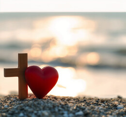 Red heart with wooden Christian cross on gravel floor in morning light