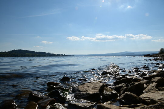 Lipno in &Scaron;umava in the Czech Republic is a beautiful blue surface and stones on the coast on a sunny day.