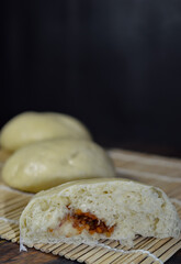 Bapao is a steamed bun with savory or sweet filling. Peanut bakpao  on wooden plate. selected focus.