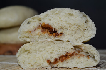Bapao is a steamed bun with savory or sweet filling. Peanut bakpao  on wooden plate. selected focus.