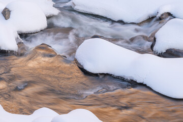 Winter landscape of Boulder Creek captured with motion blur and framed by ice and snow, Rocky Mountains, Colorado, USA