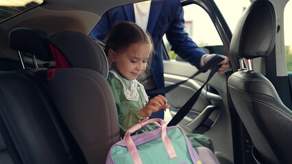 child seat car. father man puts girl daughter child seat car. happy family. schoolboy child seat....