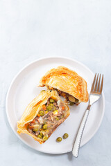 Sliced beef pot pie on plate, vertical top view, copy space