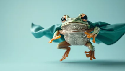 Foto op Canvas Superhero frog, creative picture of cute animal wearing cape and mask jumping and flying on light background, copy space. Leader, funny animals studio shot © LeoOrigami